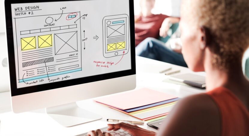 mulher em frente a um monitor, projetando a arquitetura da criação de site