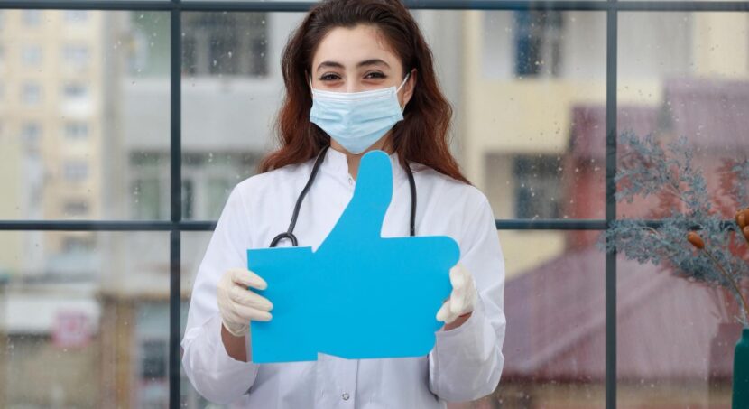 marketing digital para médicos; jovem médica segura um botão de curtir de redes sociais