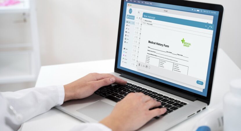 dentista com as mãos em um notebook acessando um site odontológico