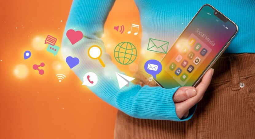 Uma mulher está segurando um smartphone exibindo ícones de redes sociais. Criação de plano de mídia social.